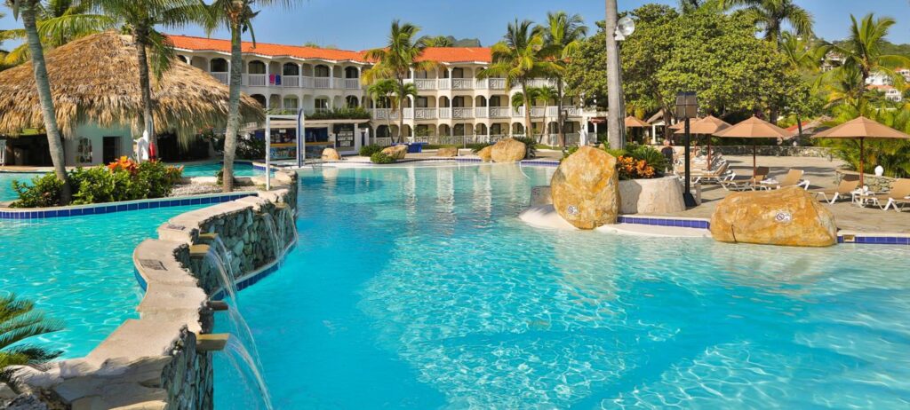 a pool with a waterfall and a building in the background
