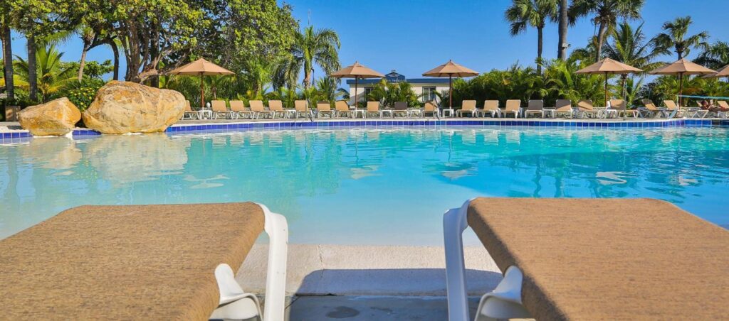 a pool with chairs and umbrellas