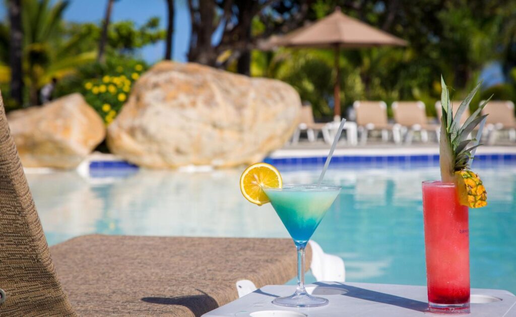 a drink on a table by a pool